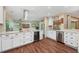 Bright kitchen with stainless steel appliances, granite counters, white cabinets and hardwood floors at 1004 Hollyberry Ct, Brandon, FL 33511