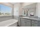 Bathroom with bathtub and separate glass enclosed shower and granite countertops near a window at 10749 Tally Fawn Loop, San Antonio, FL 33576