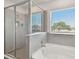 Bathroom with bathtub and separate glass enclosed shower and window with blinds at 10749 Tally Fawn Loop, San Antonio, FL 33576