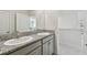 Bathroom featuring dual sinks, granite countertops, and modern fixtures at 10749 Tally Fawn Loop, San Antonio, FL 33576