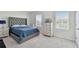 Bedroom with carpeted floors featuring a dresser and a comfortable queen size tufted bed near the window at 10749 Tally Fawn Loop, San Antonio, FL 33576