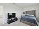 Bedroom with carpeted floors featuring a television and a comfortable queen size tufted bed with pillows at 10749 Tally Fawn Loop, San Antonio, FL 33576