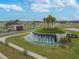 Aerial view of the neighborhood's fountain with landscaping, a sidewalk, and an open area at 10749 Tally Fawn Loop, San Antonio, FL 33576