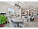 Elegant dining area featuring a round table, grey chairs, and a view into the adjacent modern kitchen at 10749 Tally Fawn Loop, San Antonio, FL 33576