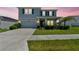 Charming two-story home featuring a manicured lawn, elegant stone accents, and an attached two-car garage at 10749 Tally Fawn Loop, San Antonio, FL 33576