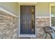 Inviting front porch featuring a stylish front door, decorative stone accents, and a Welcome mat at 10749 Tally Fawn Loop, San Antonio, FL 33576