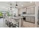 A kitchen island with seating faces a large sliding glass door and provides dining for the space at 10749 Tally Fawn Loop, San Antonio, FL 33576