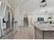 Open-concept kitchen with stainless steel appliances, granite countertops, and tile flooring leading to the living area and staircase at 10749 Tally Fawn Loop, San Antonio, FL 33576