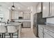 Modern kitchen featuring granite countertops, stainless steel appliances, an island with seating, and gray cabinetry at 10749 Tally Fawn Loop, San Antonio, FL 33576