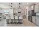 Modern kitchen with granite countertops, stainless steel appliances, kitchen island with seating and stylish pendant lighting at 10749 Tally Fawn Loop, San Antonio, FL 33576