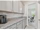 A kitchen features grey cabinets and counters and stainless steel handles and is bright and clean at 10749 Tally Fawn Loop, San Antonio, FL 33576