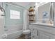 Well-lit bathroom featuring a shower-tub combo and a vanity with marble countertops at 1077 Captains Way, Tarpon Springs, FL 34689