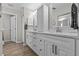 Bright bathroom boasts double vanity with framed mirrors, and white cabinets for plenty of storage at 1077 Captains Way, Tarpon Springs, FL 34689