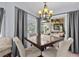 Dining area featuring a modern chandelier, neutral tones, and slider doors to the outdoor patio at 1077 Captains Way, Tarpon Springs, FL 34689