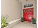 Inviting entryway features bright red double doors adorned with decorative wreaths and manicured shrubs at 1077 Captains Way, Tarpon Springs, FL 34689