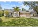 Attractive single Gathering home showcasing a well-kept lawn, mature trees, and a two-car garage at 1077 Captains Way, Tarpon Springs, FL 34689