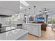 Open-concept kitchen with island, white cabinetry, and stainless steel appliances connected to the living area at 1077 Captains Way, Tarpon Springs, FL 34689