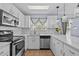 Bright kitchen with white cabinets, stainless steel appliances, marble countertops, and lots of natural light at 1077 Captains Way, Tarpon Springs, FL 34689