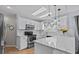 Beautiful kitchen with white cabinetry, stainless steel appliances, marble countertops, and modern pendant lighting at 1077 Captains Way, Tarpon Springs, FL 34689
