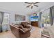 Comfortable living room featuring tile floors, a ceiling fan, a TV, and access to the screened-in lanai at 1077 Captains Way, Tarpon Springs, FL 34689