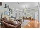 Spacious living room featuring hardwood floors, a comfortable leather sofa, and elegant decor at 1077 Captains Way, Tarpon Springs, FL 34689