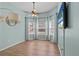 Bright living room with wood flooring, light blue walls, and three large windows at 1077 Captains Way, Tarpon Springs, FL 34689