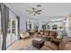 Open-concept living space with tile flooring, a ceiling fan, and access to the kitchen and screened-in patio at 1077 Captains Way, Tarpon Springs, FL 34689