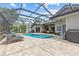 Inviting pool with pavers, lounge chairs and shaded seating under screened enclosure at 1077 Captains Way, Tarpon Springs, FL 34689