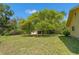 Expansive backyard with green grass and several trees offer shade and a private setting for outdoor activities at 1379 Matthew Ave, Spring Hill, FL 34609
