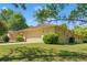 Beige single-story home with a large two-car garage and a lush green lawn at 1379 Matthew Ave, Spring Hill, FL 34609