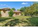 Sprawling lawn in front of the single-story beige home with mature landscaping around the house at 1379 Matthew Ave, Spring Hill, FL 34609