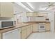 Kitchen with white appliances, plenty of counter space, and tile flooring at 1379 Matthew Ave, Spring Hill, FL 34609