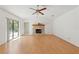 Bright living room featuring a stone fireplace, wood floors and sliding glass doors to the pool area at 1379 Matthew Ave, Spring Hill, FL 34609