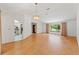 Open living room showcasing wood flooring, a chandelier, and open access to the kitchen at 1379 Matthew Ave, Spring Hill, FL 34609