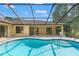 Screened-in pool with sparkling water surrounded by patio space and access to the lanai at 1379 Matthew Ave, Spring Hill, FL 34609