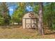 This property features a shed with double doors and a decorative window for storing tools and gardening supplies at 1379 Matthew Ave, Spring Hill, FL 34609