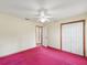 Bedroom with pink carpet, double closet doors, and access to other rooms at 1414 Stephens Oak Ct, Plant City, FL 33567