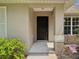 A home's entryway featuring a classic black door and neutral-toned exterior at 1414 Stephens Oak Ct, Plant City, FL 33567