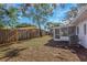 Spacious backyard features a grassy area, a screen porch, and a wooden fence for privacy at 1432 S Keene Rd, Clearwater, FL 33756