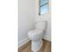 Bright bathroom features sleek white toilet, window, and modern trim at 1432 S Keene Rd, Clearwater, FL 33756