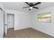 Well-lit bedroom has wood-look flooring, a ceiling fan, and natural light at 1432 S Keene Rd, Clearwater, FL 33756