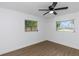 Clean bedroom boasts wood-look floors, a ceiling fan, and plenty of light at 1432 S Keene Rd, Clearwater, FL 33756