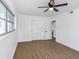 Updated bedroom has wood-look flooring, a ceiling fan, and closet for storage at 1432 S Keene Rd, Clearwater, FL 33756