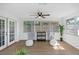 Bright Florida room features ample seating, a ceiling fan, and lots of windows, creating a cozy and inviting space at 1432 S Keene Rd, Clearwater, FL 33756
