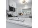Bright white kitchen with stainless steel appliances, quartz countertops, and view to dining room at 1432 S Keene Rd, Clearwater, FL 33756