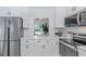 Bright kitchen featuring white cabinets, stainless steel appliances, and quartz countertops at 1432 S Keene Rd, Clearwater, FL 33756