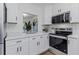 Bright white kitchen featuring quartz countertops, stainless steel appliances, and modern cabinets at 1432 S Keene Rd, Clearwater, FL 33756