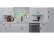 Bright white kitchen featuring quartz countertops, stainless steel appliances, and a modern sink at 1432 S Keene Rd, Clearwater, FL 33756