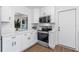 Bright kitchen featuring white cabinets, stainless steel appliances, and quartz countertops at 1432 S Keene Rd, Clearwater, FL 33756
