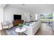 Bright living area with hardwood floors, sleek furniture, TV console, and lots of natural light, creating a welcoming space at 1432 S Keene Rd, Clearwater, FL 33756